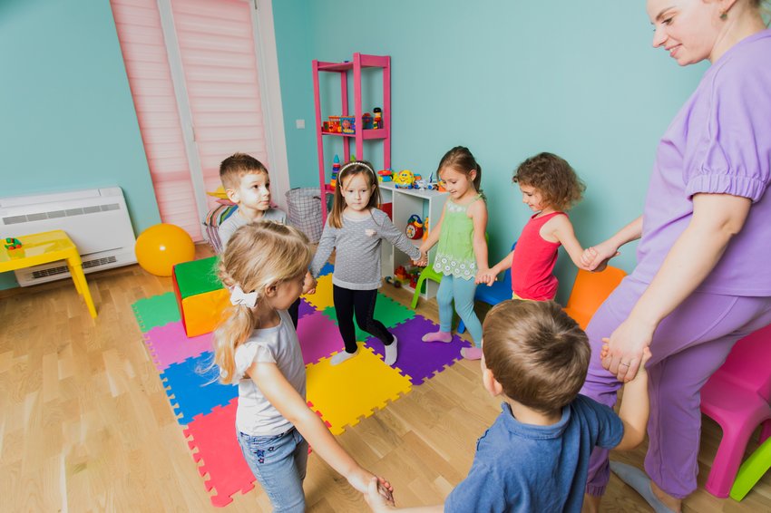 beautiful preschool teacher walking with kids circle dance class learning new teambuilding techniques happy kids with their young teacher daycare 1 copia copia