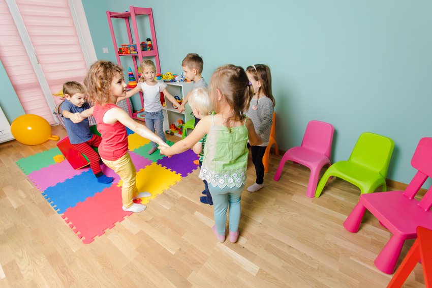 niños de preescolar en círculo cogidos de la mano aprendiendo trabajo en equipo