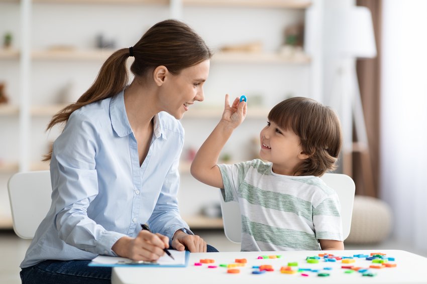 cute little boy showing pronouncing sound o with his teacher exercising together classroom copia