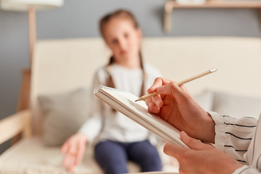 female child having session with psychologist who takes notes her emotional mental state carefully listening girl s concerns issues copia