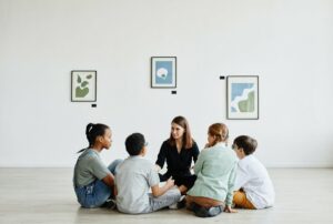 full length view diverse group children sitting circle class art gallery copy space copia