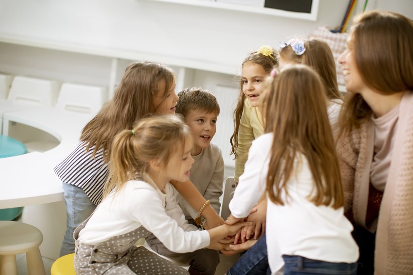 group cute preschool kids put hands together with their nursery teacher copia